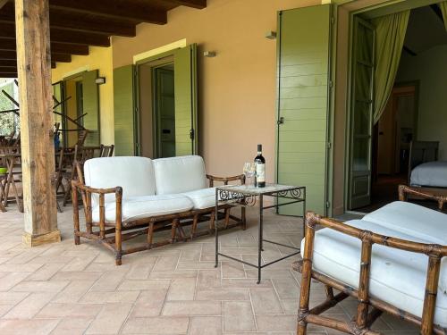 a patio with chairs and a table with a bottle of wine at Lagotto House-Apartment in the Langhe in Novello
