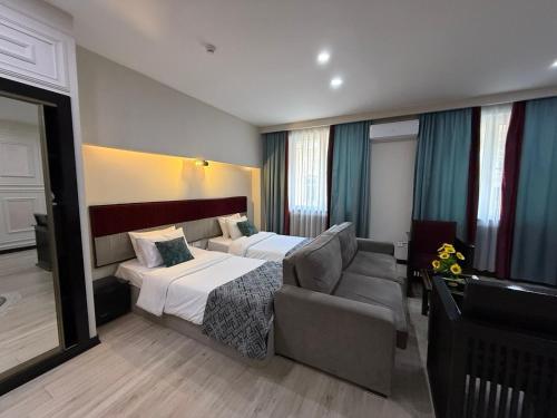 a hotel room with a bed and a couch at Pilot By Haz Hotel in Baku