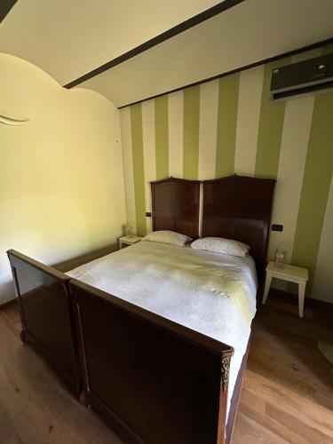 a bed in a room with green and white stripes at Lagotto House-Apartment in the Langhe in Novello