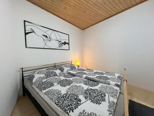 a bedroom with a bed with a black and white comforter at Apartment Theresa - LANDLUFT in Bad Aussee