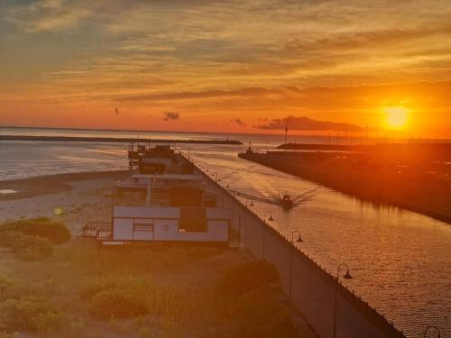 a sunset on the beach with a boat in the water at Emilù Guest House in Pescara