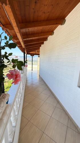 a patio with a wooden roof with flowers on it at Apartments Berti in Sarandë