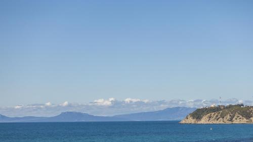 a view of the ocean with mountains in the background at Idou Malabata Beach and SPA in Tangier