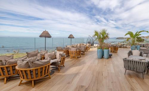 a restaurant with chairs and a view of the ocean at Idou Malabata Beach and SPA in Tangier