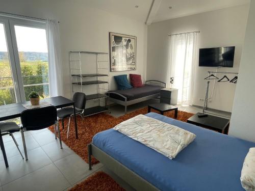 a bedroom with a bed and a table and a couch at Schöne Unterkunft - Nähe Schweiz in Gottmadingen