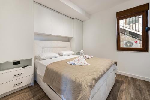 a bedroom with a bed with a doll on it at Skyline Residences in Bigovo