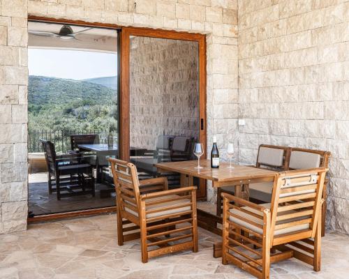 a dining room with a table and chairs on a patio at Skyline Residences in Bigovo