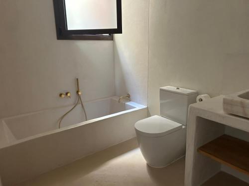 a bathroom with a toilet and a tub and a sink at Ses Terrisses Hotel in Palafrugell