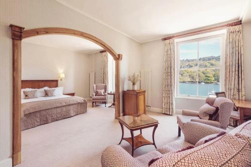 a bedroom with a bed and a large window at Lakeside Hotel and Spa in Newby Bridge