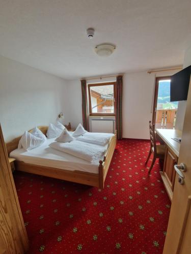 a hotel room with a bed and a window at Hotel Tonnerhof in Racines