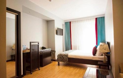 a hotel room with a bed and a mirror at Pilot By Haz Hotel in Baku