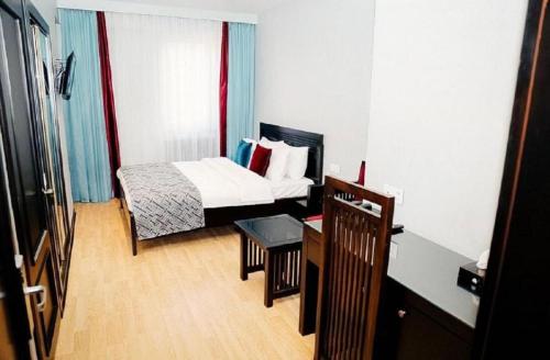 a hotel room with a bed and a table in it at Pilot By Haz Hotel in Baku