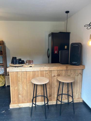 a counter with two stools in front of a kitchen at Basement Tomorrowland 2025 in Mellet