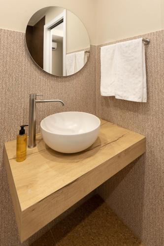 a white sink on a wooden counter in a bathroom at MIRARI Design Rooms in Cala Gonone