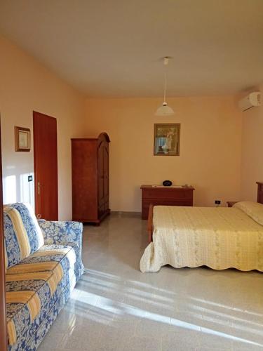 a bedroom with two beds and a couch at Casa Presenza in Santa Elisabetta