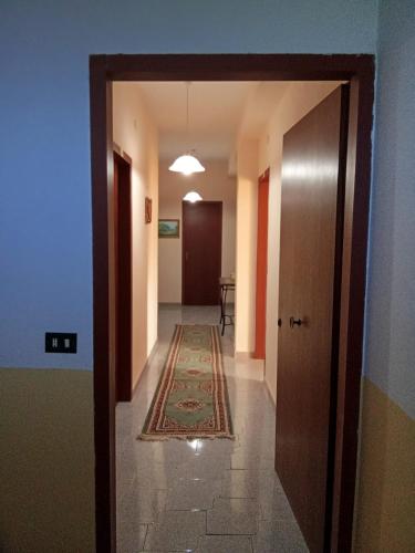 an empty hallway with a door and a rug at Casa Presenza in Santa Elisabetta