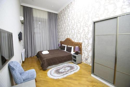 a bedroom with a bed and a chair in it at Pilot By Haz Hotel in Baku