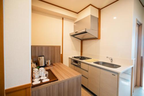 a small kitchen with a sink and a stove at Best Western Okinawa Kouki Beach in Nago