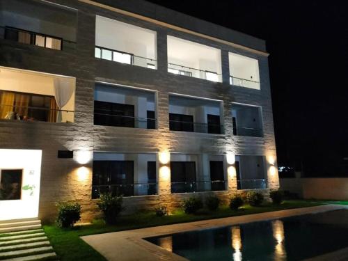 a building with a pool in front of it at night at Diani Beachfront Villa Amani at Diani in Ukunda