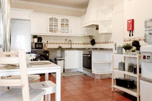 cocina con armarios blancos y suelo de baldosa roja en Quinta Alto da Capela, en Setúbal