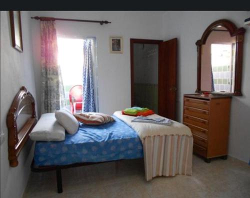 a bedroom with a bed with a dresser and a mirror at Ocaña in La Puebla de los Infantes
