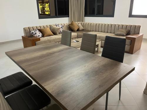 a living room with a wooden table and a couch at Malabata Gandori Tanger in Tangier
