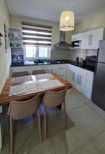 cocina con mesa de madera con sillas y nevera en Le Mirage Exotique, en Flic en Flac