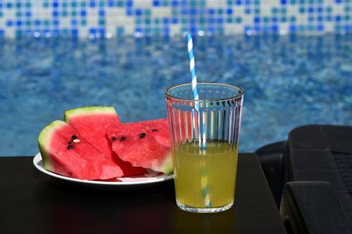 a plate of watermelon and a glass of orange juice at Villa Tisa in Privlaka