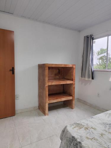 a bedroom with a bed and a wooden book shelf at Charmoso Village no Povoado de Coqueiros in Jandaíra