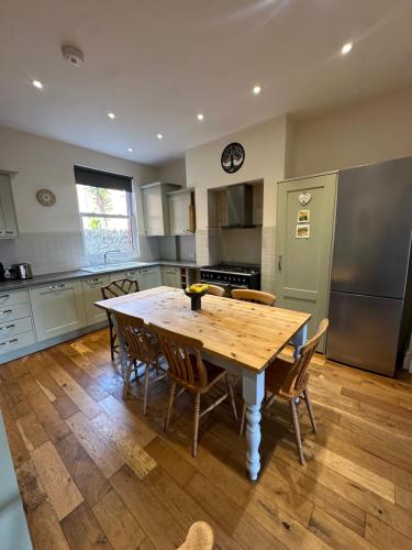 Una cocina con una mesa y sillas de madera. en Caroline's House, en Swanage