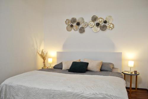 a bedroom with a large white bed with two lamps at Apartmán u Fontány in Poděbrady