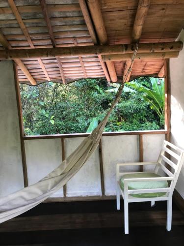 a hammock and a chair in a room with a window at Refugio Cumaná Entero in San Rafael