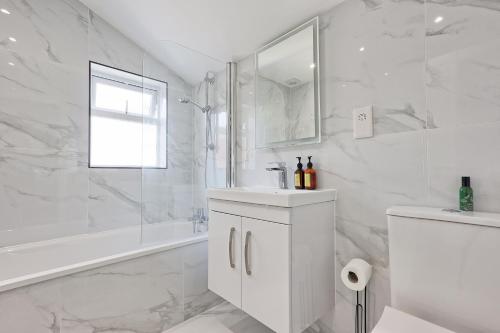 WrittleにあるStudio By Homestyles Hosts Short Lets & Serviced Accommodation Widford With Free WiFiの浴槽と洗面台のある白いバスルーム