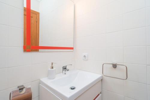 a white bathroom with a sink and a mirror at Can Joan in Cala Figuera