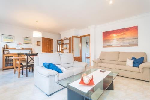 a living room with two couches and a table at Can Joan in Cala Figuera