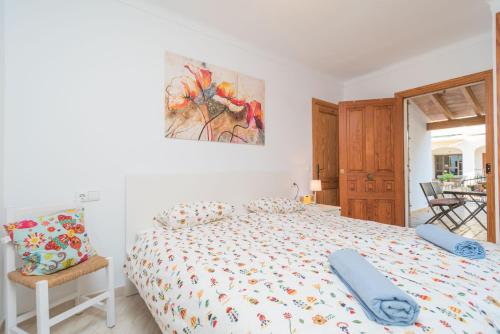a bedroom with a bed and a painting on the wall at Can Joan in Cala Figuera