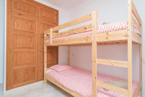 a bedroom with two bunk beds and a closet at Can Joan in Cala Figuera