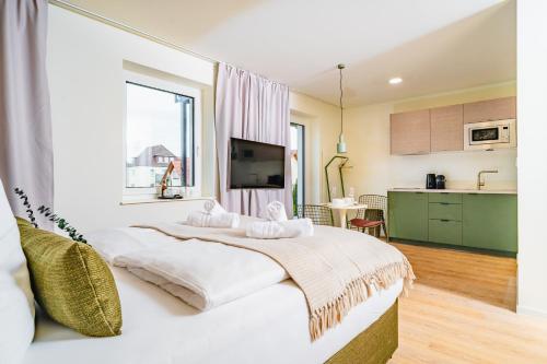 a bedroom with a large bed and a kitchen at OH KEY Apartments - unlock your stay - Frankfurter Str in Fulda