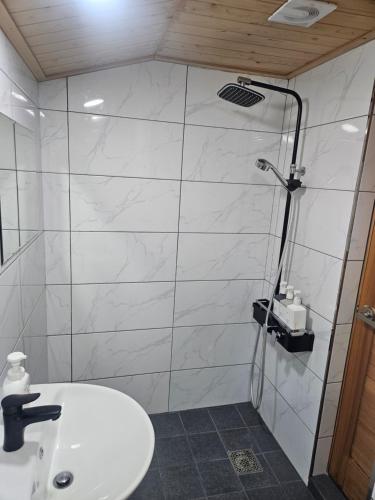 a white bathroom with a shower and a sink at SiEunJae in Gyeongju