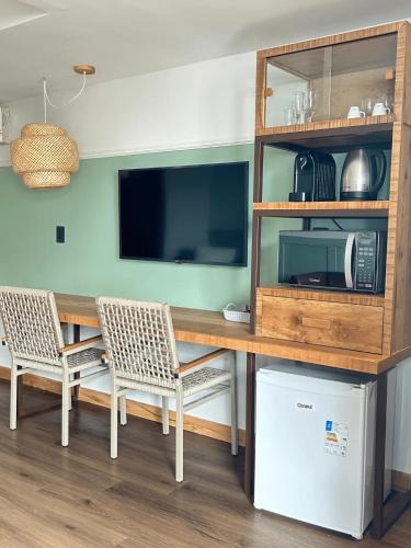 a dining room table with a microwave and a tv at Pousada dos Sonhos in Florianópolis