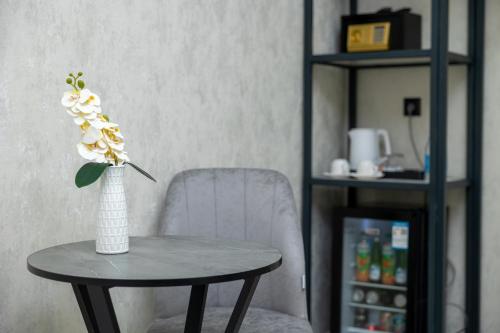 a vase of flowers on a table next to a chair at Marmaris Saray hotel NEW in Tashkent