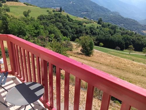 a red deck with a table and a chair on a hill at Chambre - Sdb Privative - Super Vue in Pallud