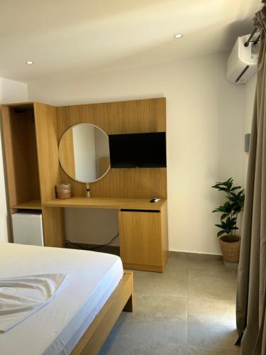a bedroom with a bed and a mirror on a wall at Koks’ Guesthouse in Himare