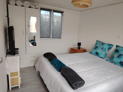 Un dormitorio con una gran cama blanca y un espejo. en La Sardine, en Fréjus