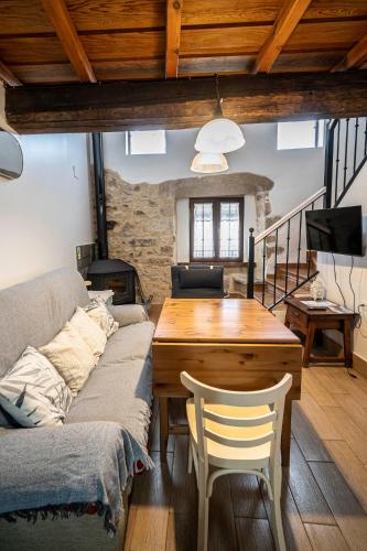 a living room with a couch and a wooden table at Casa Rural La Barquilla in Acebo