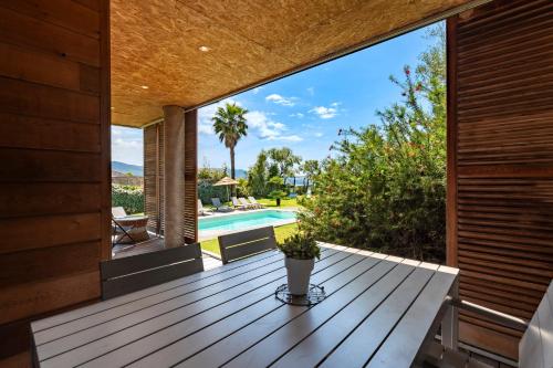 une terrasse avec vue sur la piscine et la maison dans l'établissement Splendide appartement T3 piscine et vue mer, à Grosseto-Prugna
