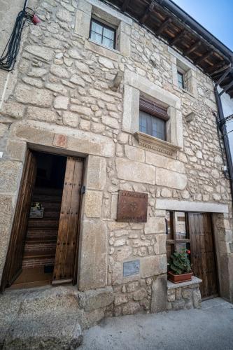 a stone building with two doors and two windows at Casa Rural La Barquilla in Acebo