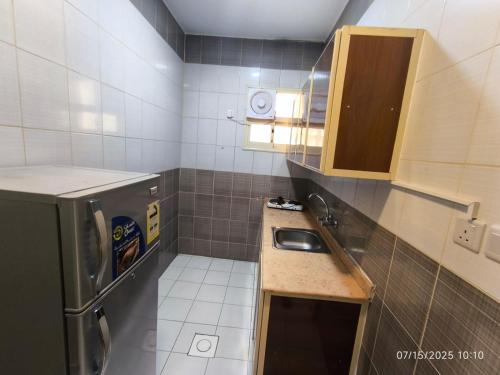 a small kitchen with a sink and a refrigerator at Qasr Aljoud Serviced Apartments in Abha