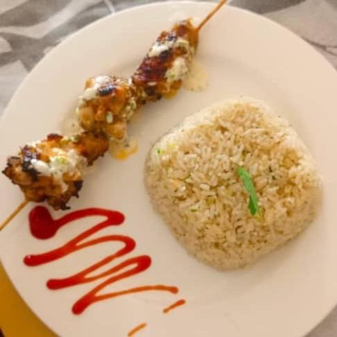 a plate of food with meat and rice on it at Hôtel chez Marie Oyouma in Port-Gentil