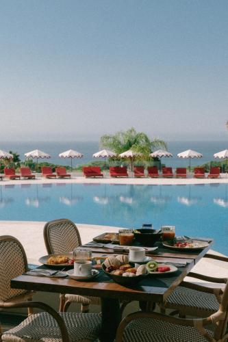 una mesa con comida junto a una piscina en Masana Algarve, en Albufeira